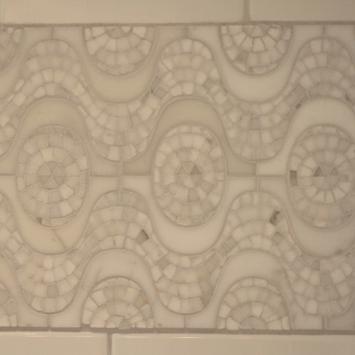 small pieces of white Carrara marble laid in a geometric pattern provide the "wow" factor in the shower