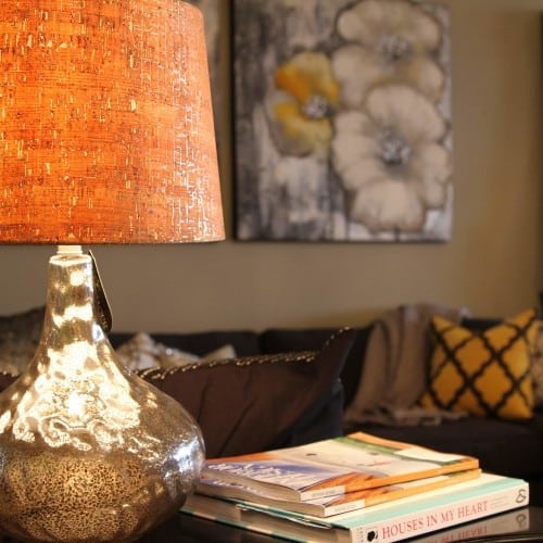 an end table with a lamp and books finishes the space and creates a cozy ambiance