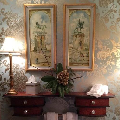 wallpapering a small space such as a powder room can really wow your guests. don't be afraid to hang art on your wallpaper - just make sure it's something you love and won't tire of easily