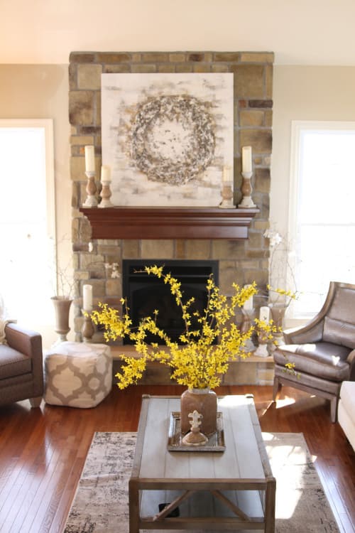 a large abstract painting above the fireplace contrasts against the dark stone