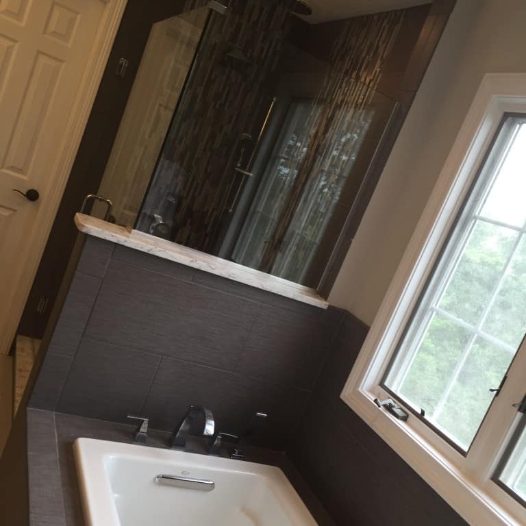 by stealing some of the space from the former tub location, we were able to give the homeowners a more spacious shower that fits their needs. coupling furniture vanities with elegant, rustic mirrors make this bathroom feel more like you are staying at a boutique hotel