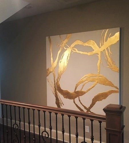 Hallways should be treated as opportunities for show-stopping art, like this large abstract white-and-gold, unframed canvas