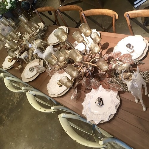 Metallic foliage, sparkle deer and gorgeous gold candelabras come together in an elegant centerpiec that spans the entire length of the table. Warmth from mixing metals and the candelabras create the perfect ambiance to make memories with loved ones